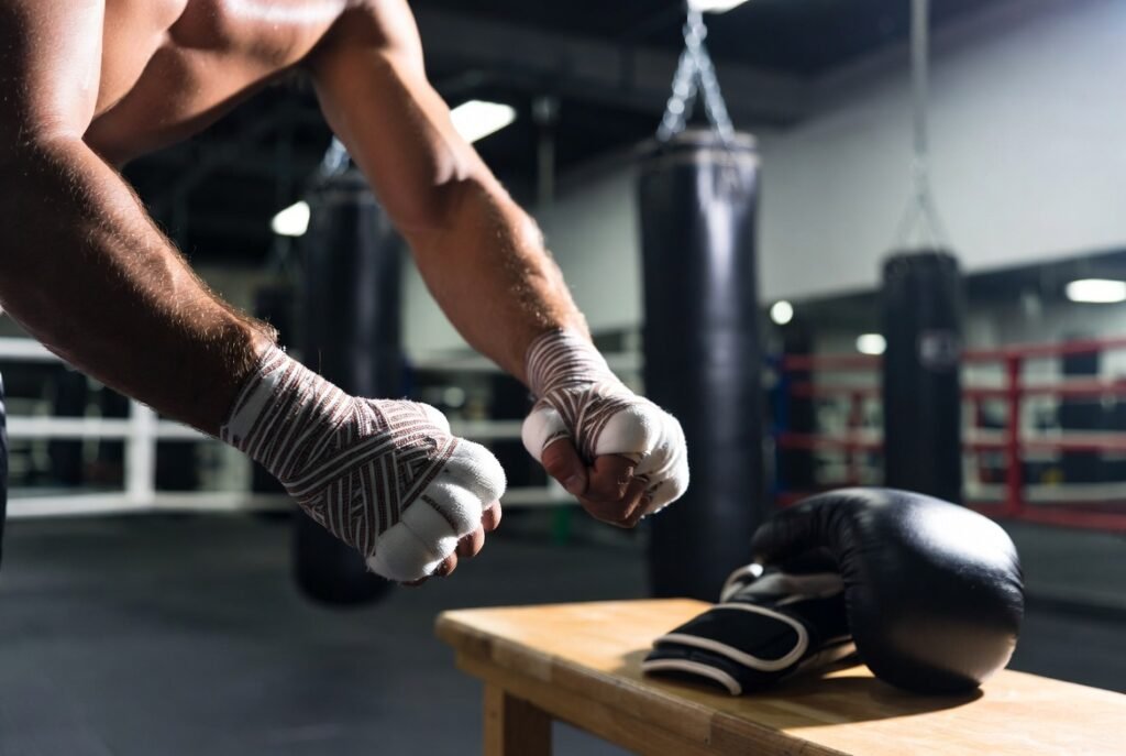 How to Prevent Hand Injuries in Boxing Training | Top Guide 1 Boxer wrapping hands before boxing training to prevent hand and wrist injuries in the gym